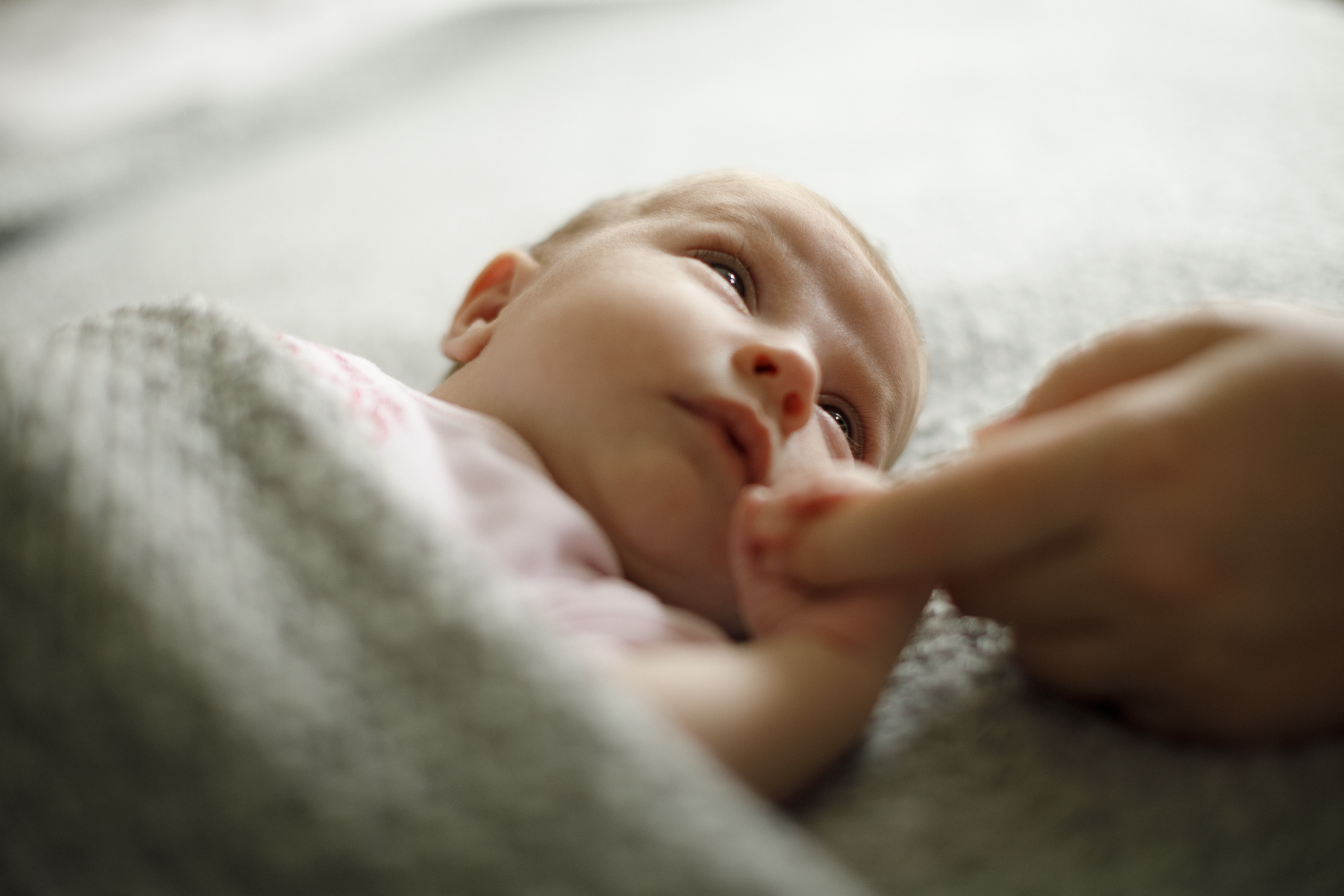 New baby holding mothers finger